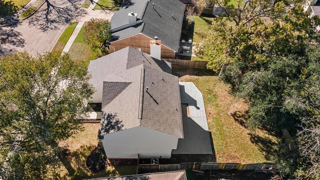 Two story home with a spacious backyard, mature trees, and a fenced perimeter, located in a quiet neighborhood.