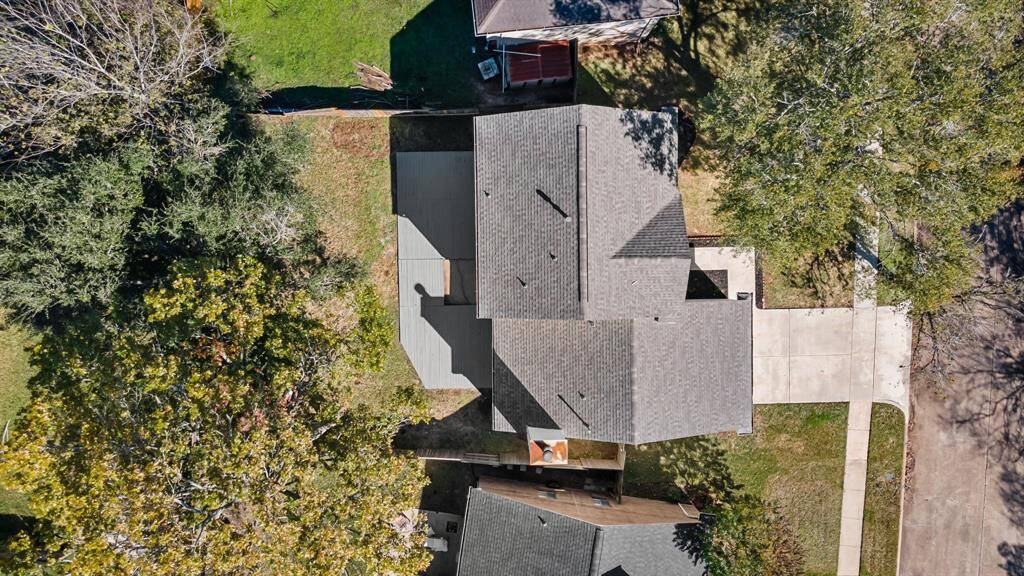 Two story home with a spacious backyard, mature trees, and a fenced perimeter, located in a quiet neighborhood.