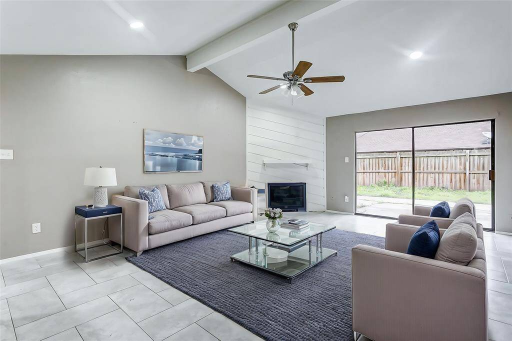 The living area highlights its open-concept design, perfect for entertaining or relaxing with family. Recessed lighting illuminates the space, enhancing the soft neutral tones. The focal-point fireplace invites cozy evenings, while the sliding glass doors bring in sunlight, making the room feel even larger. The flow from indoor to outdoor spaces makes this the ultimate spot for gatherings or quiet nights in.