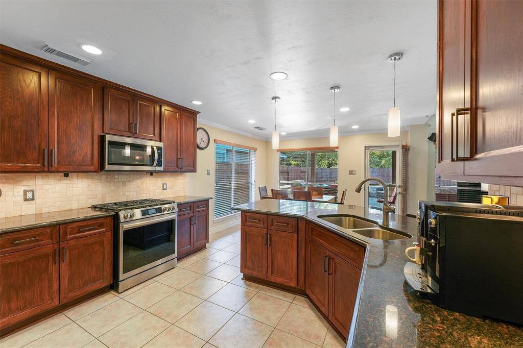 This is a spacious kitchen includes a gas range and has a view into an adjoining dining area and access to the backyard.
