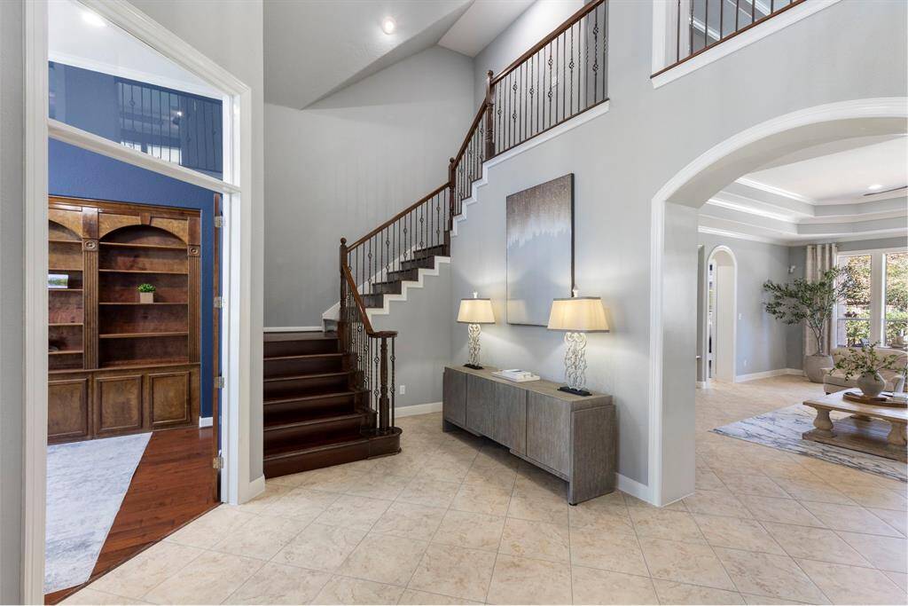 As you enter the home, you'll be greeted by the study to your left, a stunning staircase that draws the eye upward, and an inviting view of the living room, creating an open and welcoming atmosphere.