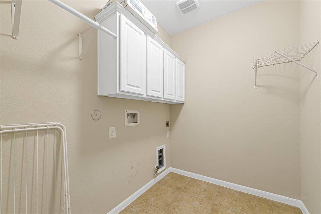 In door laundry room offers extra storage space, area to hang clothes, and gas or electric dryer connections.