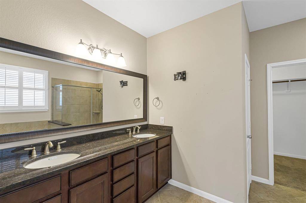 En-suite bath with dual sinks and tons of storage means no more fighting for counter space in the mornings.
