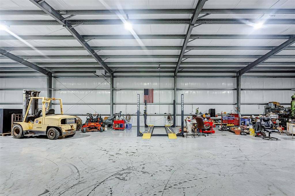 Spacious warehouse workshop featuring a convenient car lift.