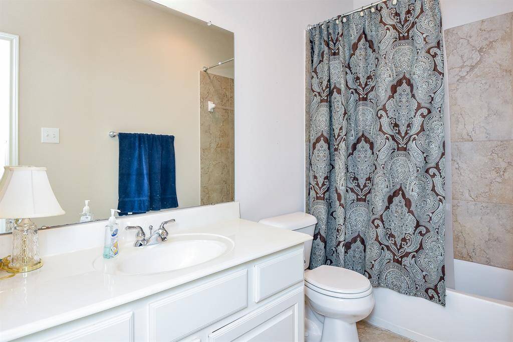 An inviting secondary bath offers combined shower/bathtub for personal options.
