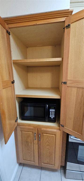 Spacious pantry with built-in cabinet storage for a microwave.