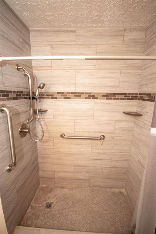 Modern, stylish shower with elegant tilework and convenient grab bars for a touch of luxury and safety.