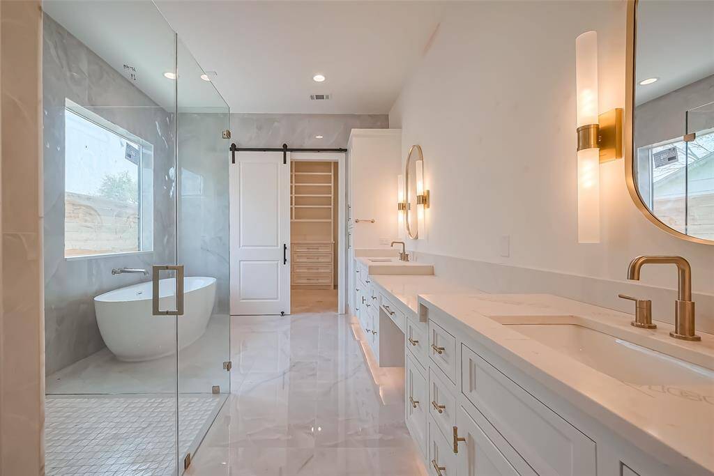 Primary Bathroom Lavish floor-to-ceiling tile for a spa-like ambiance. Photos as of 03/20/2025.