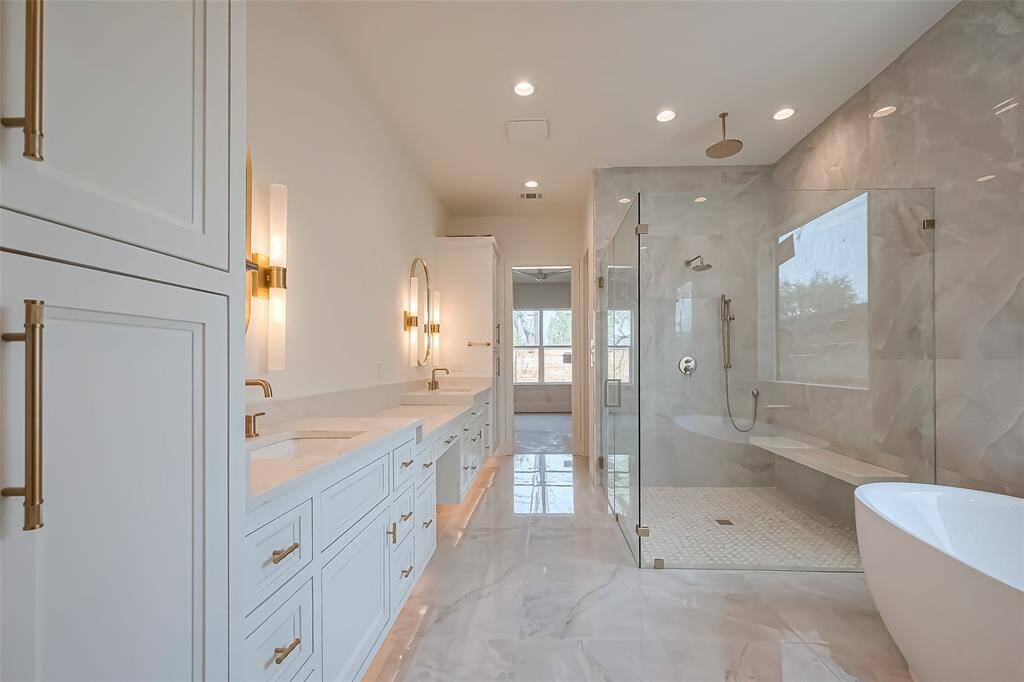 Primary Bathroom Lavish floor-to-ceiling tile for a spa-like ambiance. Photos as of 03/20/2025.