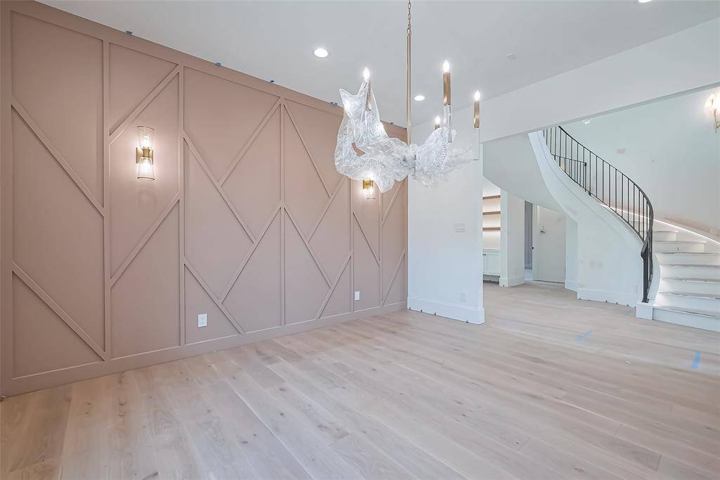 Elegant dining room with statement chandelier and wall paneling. Photos as of 03/20/2025.