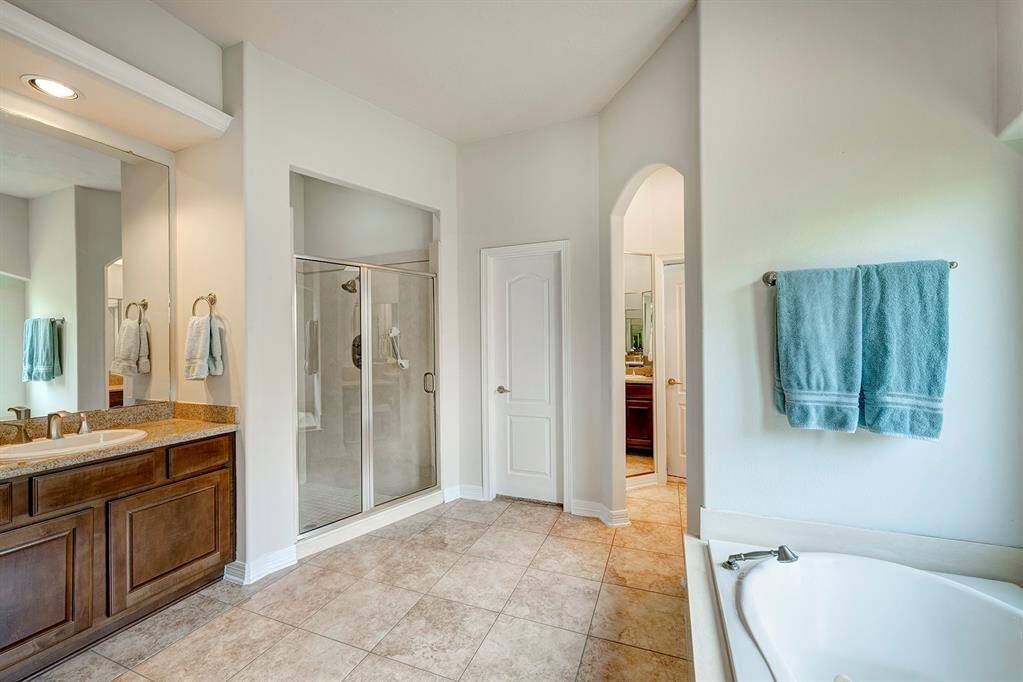 The first floor primary bath has double sinks, linen closet, soaking tub, glass enclosed shower, and a large wrap-around closet.