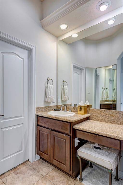 The second sink in the first floor primary bath has a seated vanity and a three-way dressing mirror - a rare find!