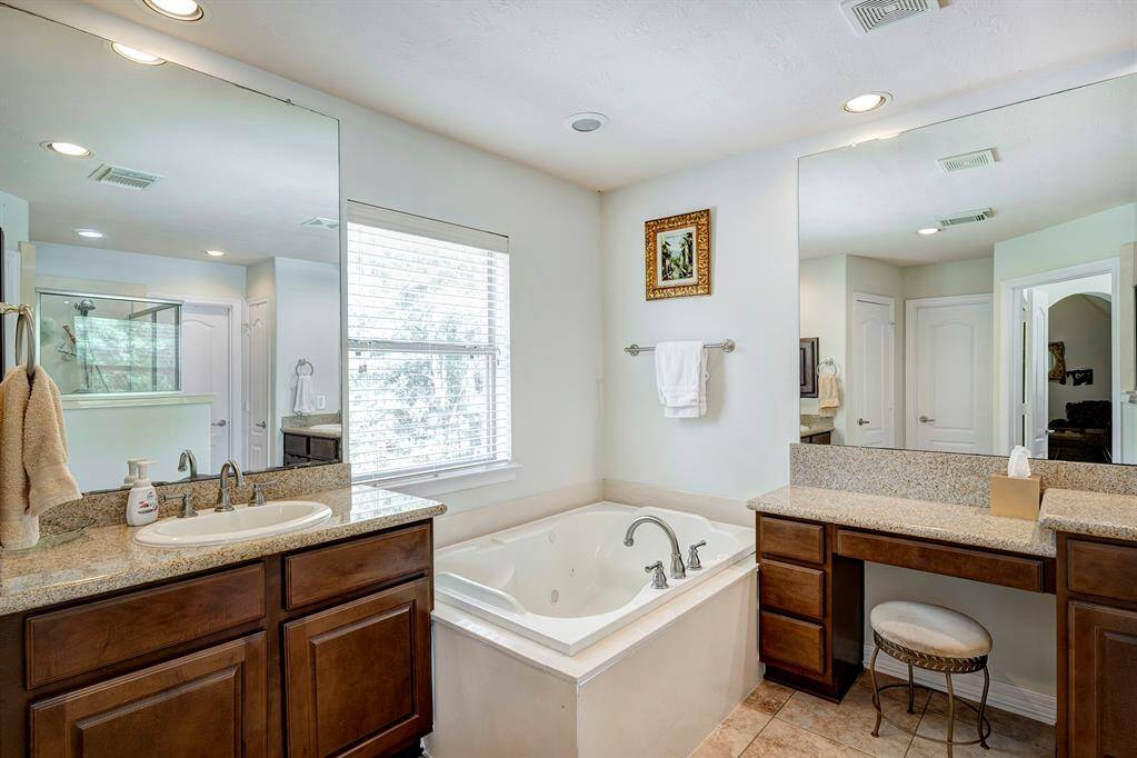 The second floor primary bath has double sinks, vanity, jetted tub, glass enclosed shower, and two closets.