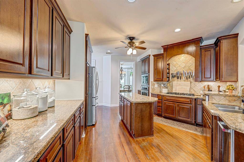Wood floors extend into the chef's kitchen, complete with island and an abundance of storage!