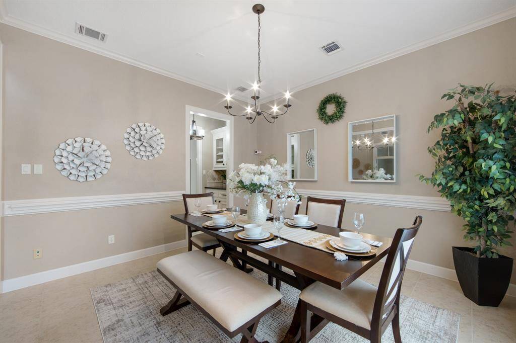 Beautiful dining room with abundant natural light, charming chandelier, and tasteful decor—perfect for entertaining guests.