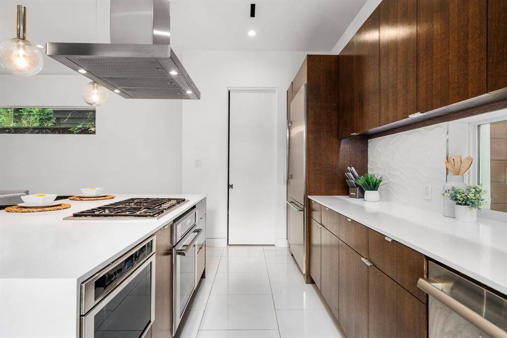 Thermador appliances, sleek solid wood low profile cabinetry, quartz countertops and textured tile backsplash create a great backdrop for the chef in the family.