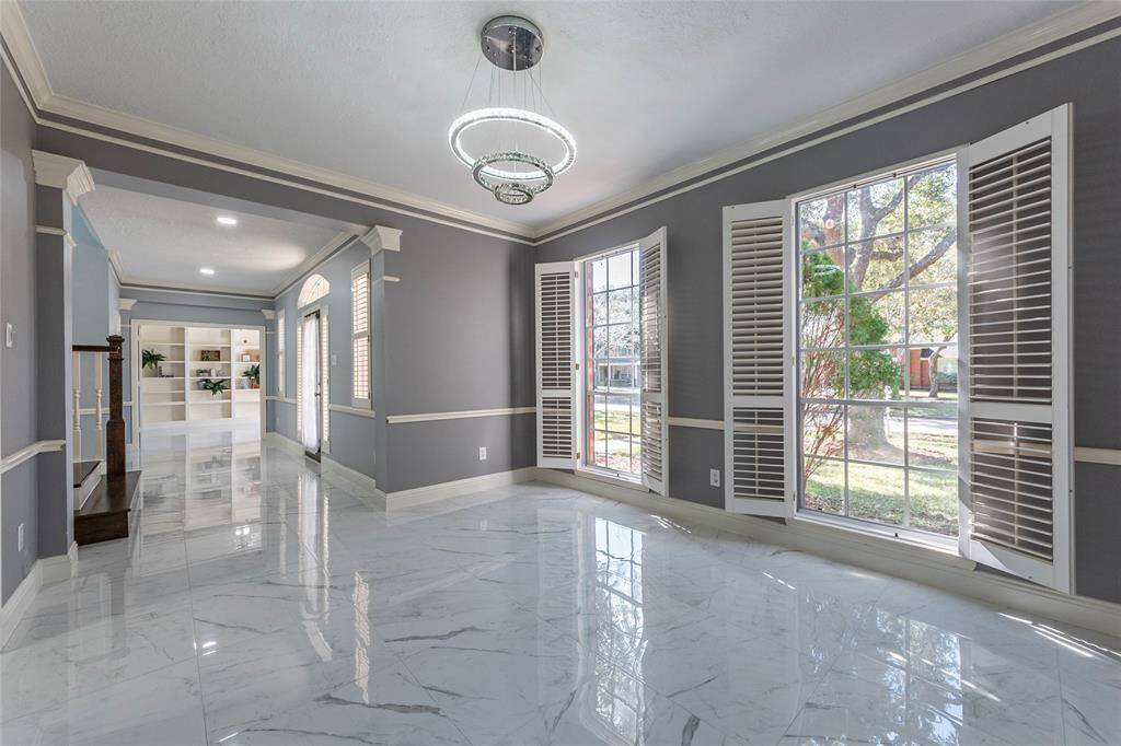 Stunning formal dining room with porcelain flooring, crown molding, chair-rail molding and updated light fixture.
