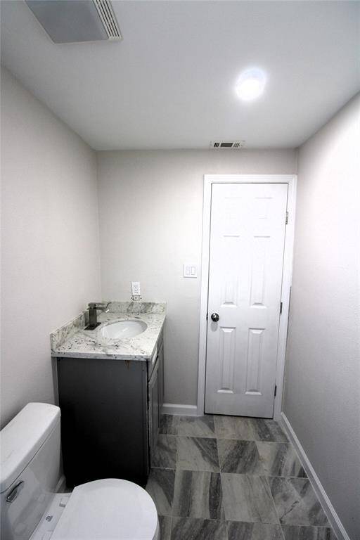 Modern, compact bathroom with a sleek design. It features neutral color palette and tiled flooring.