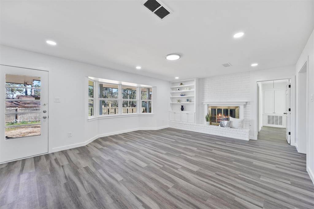 Living room with beautiful new windows. Also includes built-ins for storage and a beautiful fireplace