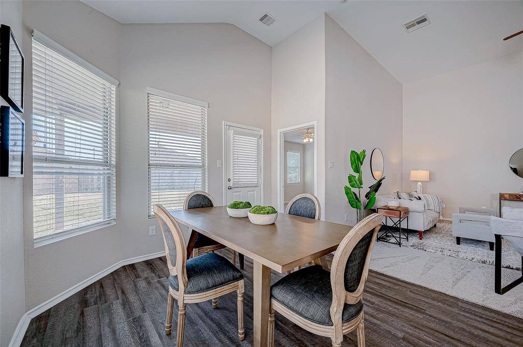 The dining area is bathed in natural light, thanks to large windows that provide a bright and airy ambiance. The open layout connects seamlessly with the living room, offering a versatile space for family meals or entertaining guests.