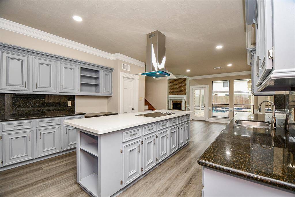 The bright breakfast room, bathed in natural light from surrounding windows, offers breathtaking views of the sparkling pool. This convenient location makes entertaining a breeze, allowing effortless transitions between indoor and outdoor spaces during poolside gatherings.