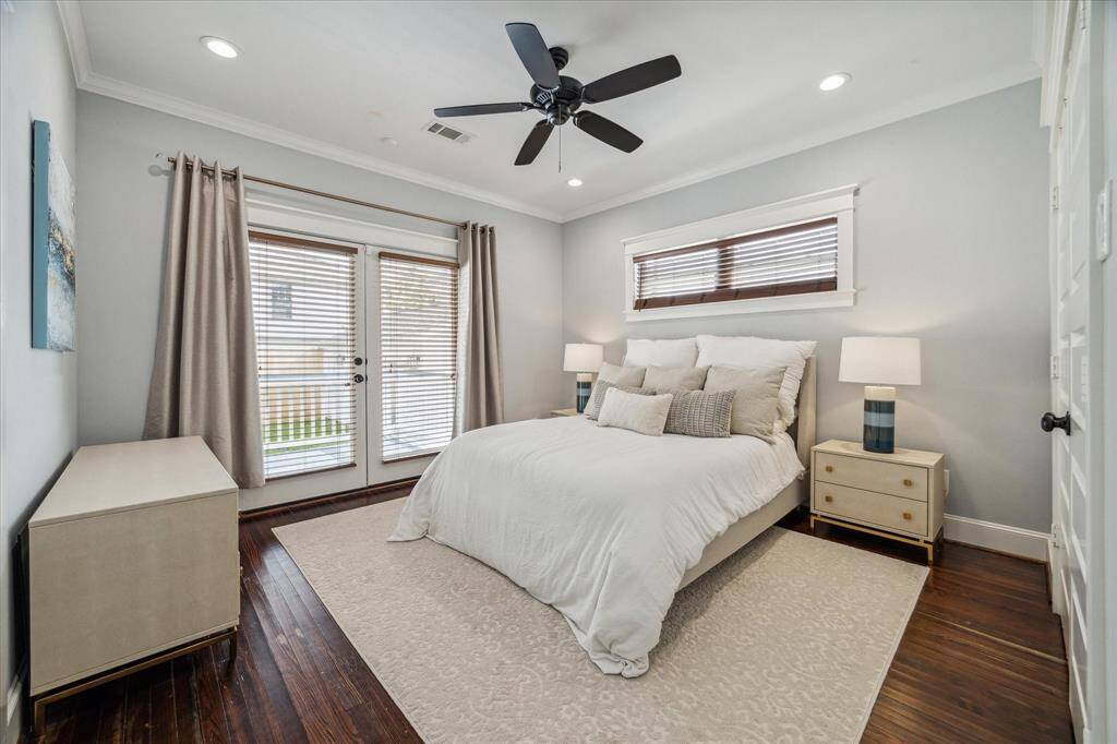 The primary bedroom, located off the back of the home, features hardwood floors, crown molding and a large closet with custom built-ins.