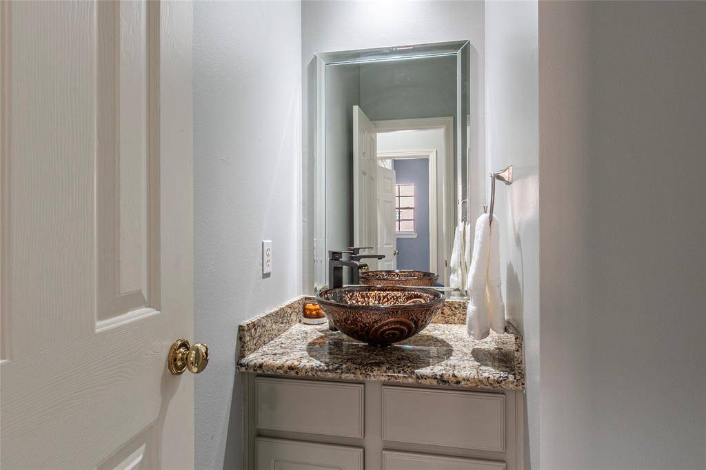 Powder room half- bath on the 1st level with granite countertops and custom sink.