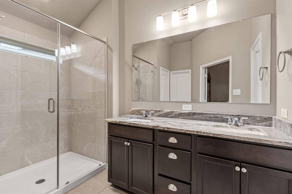 The primary bath provides a walk-in shower, granite counters, double sinks and walk-in closet.