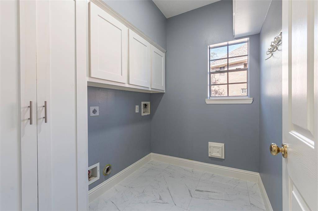 Large utility room with porcelain tile floors and extensive built-in storage.