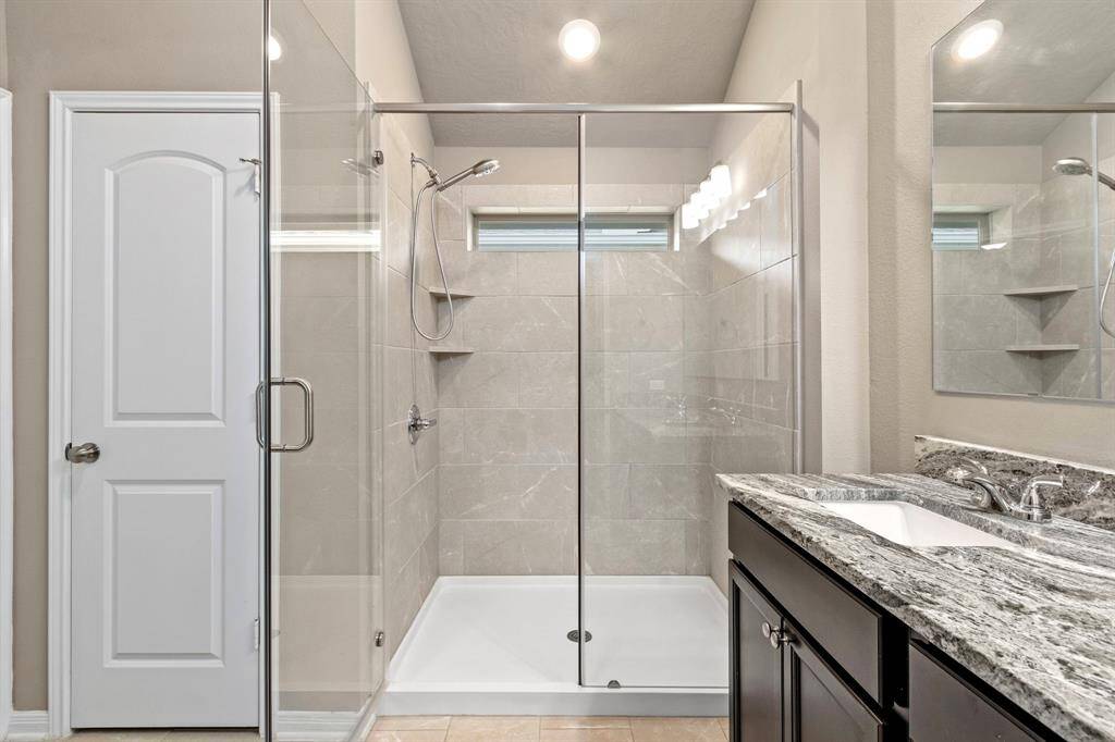 Another view of the primary bath with large walk-in shower and linen closet.