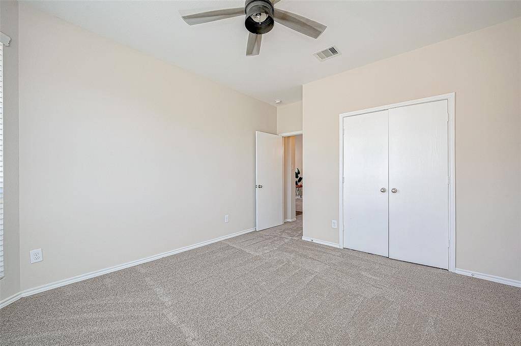 This secondary bedroom provides a tranquil retreat with its neutral tones, BRAND-NEW carpeting, and a stylish ceiling fan for added comfort. The spacious closet and natural light filtering through the window make it both functional and inviting, perfect for guests or family members.