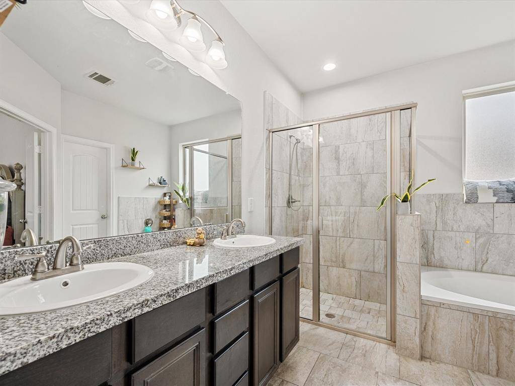 It includes a dark wood vanity with a granite countertop and a double sink mirror!