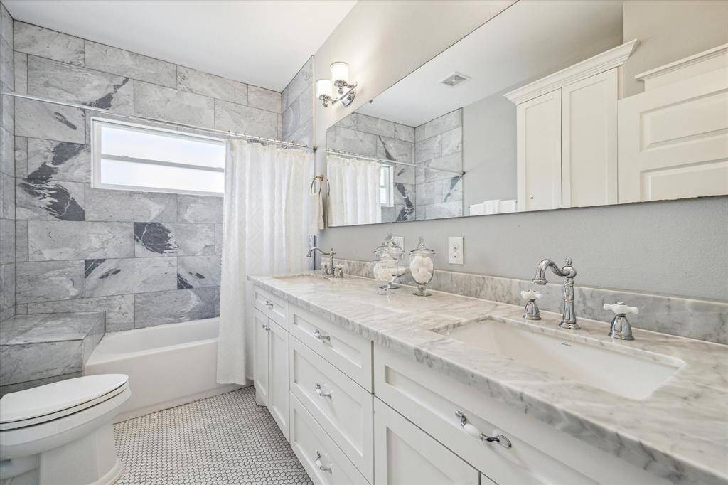 The beautifully appointed full bath with dual sinks, oversized vanity, tub/shower combo, and great storage completes the interior space.