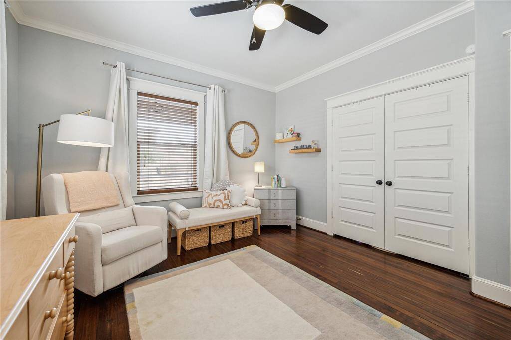 The guest bedroom, located off the front of the home, features hardwood floors, crown molding, and a spacious closet.
