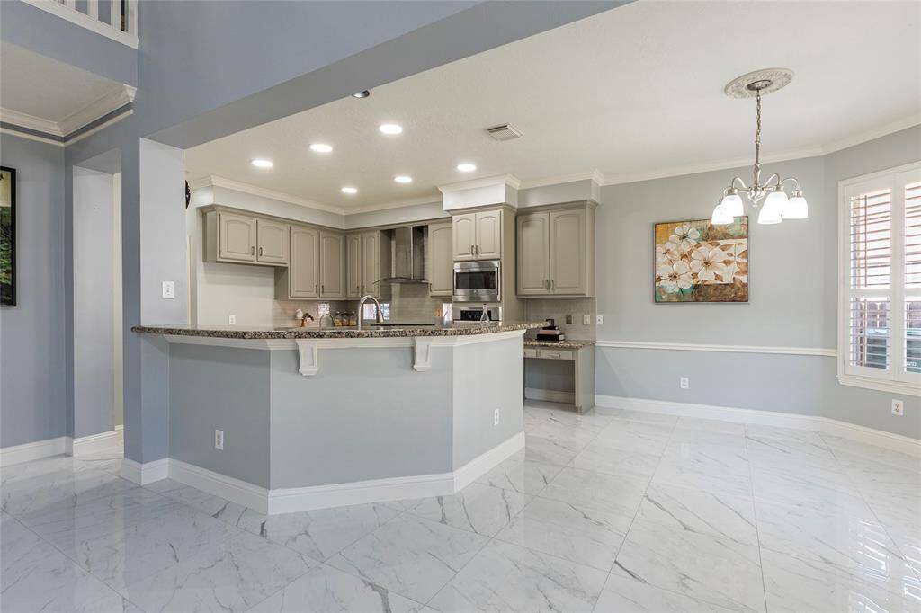 Spacious open-concept breakfast and kitchen area with crown molding, fresh paint and recessed canned light