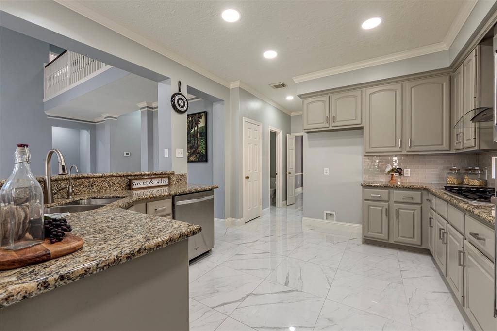Desirable hi/lo large breakfast bar with water softener and undermount sink. Recently updated vent hood above gas range & updated stainless steel appliances; recently replaced microwave, huge walk-in pantry and crown molding.
