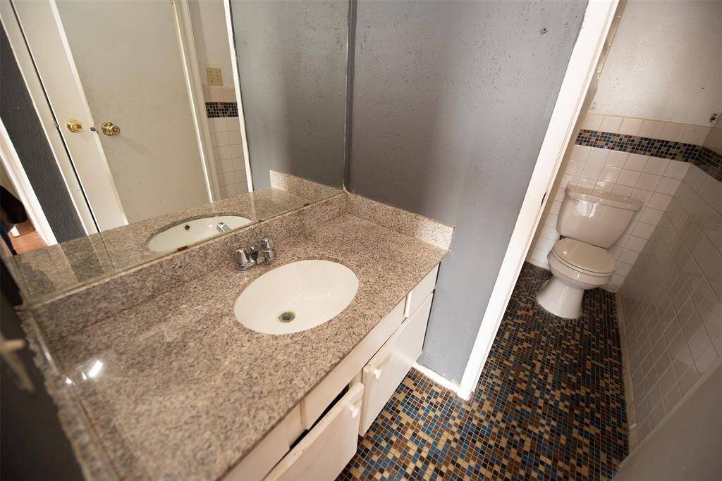 Private bath with granite vanity and hidden bathing area.