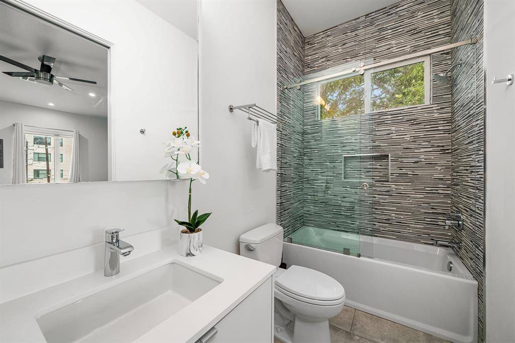 En-suite bathroom - notice the designer textured tile around the tub/shower combo that goes all the way to the ceiling.
