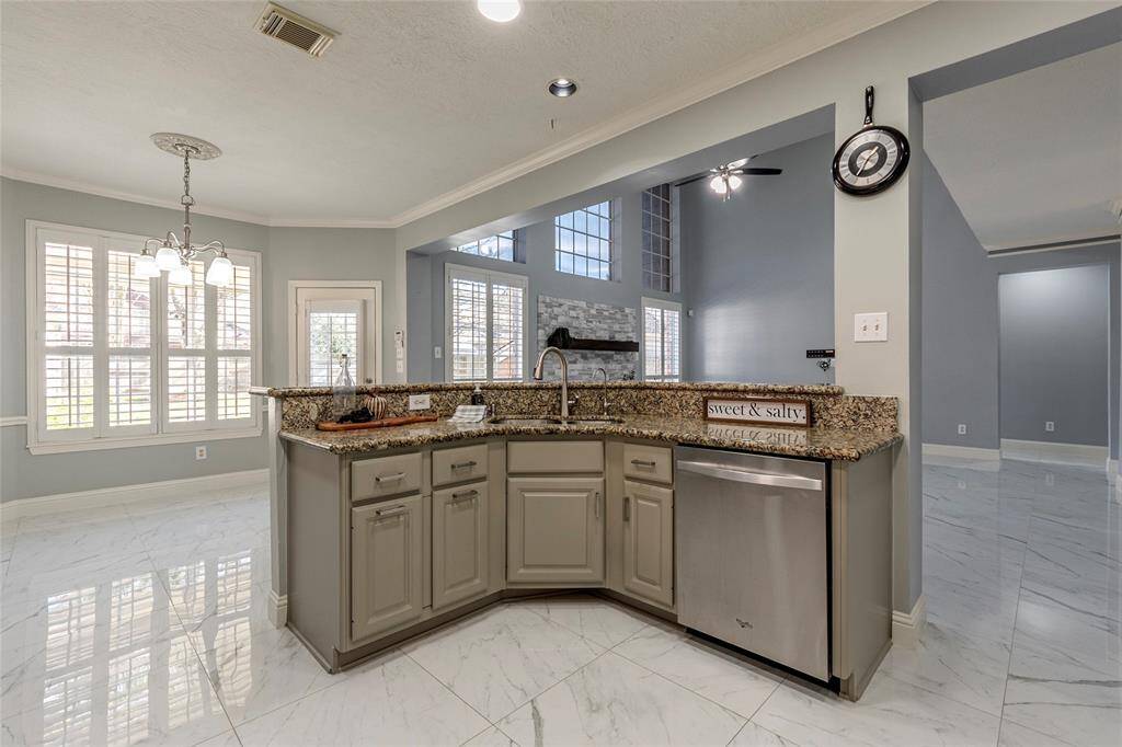 Undermount stainless steel sink with upscale faucet, granite counters, and hi/lo breakfast bar.