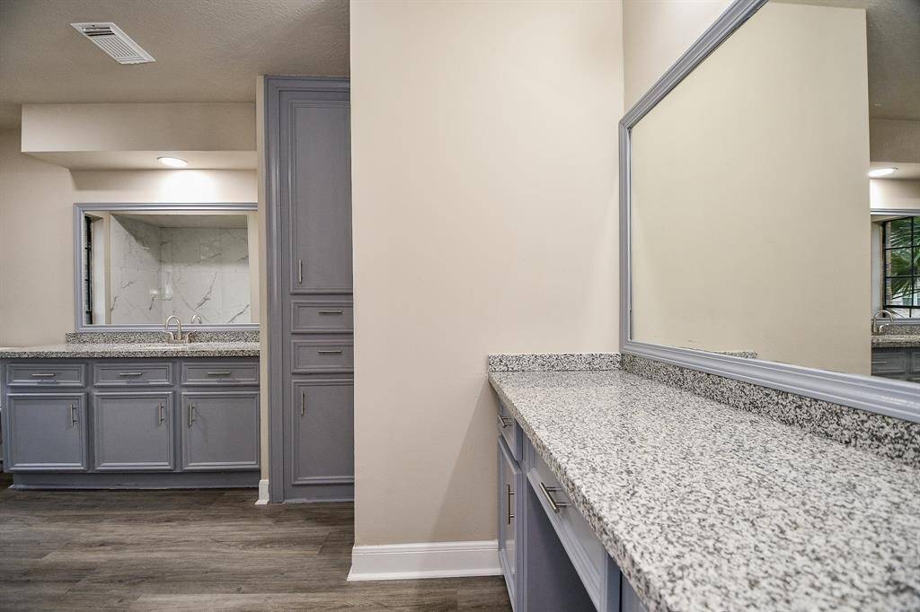 This vantage point of the game room highlights the dramatic staircase leading to a cozy loft area, perfect for a quiet retreat or additional entertainment space. A glimpse of the wet bar, double doors leading to a landing, plus access to a bathroom further emphasize the functionality and versatility of this impressive entertainment area.