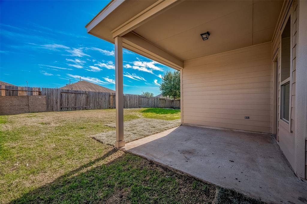 The covered patio provides a perfect outdoor retreat, offering shade and a cozy spot to enjoy the spacious backyard.