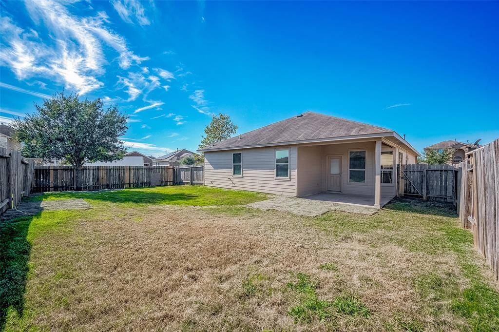 A spacious backyard featuring a charming, covered patio area attached to the home, perfect for relaxing or hosting outdoor gatherings.