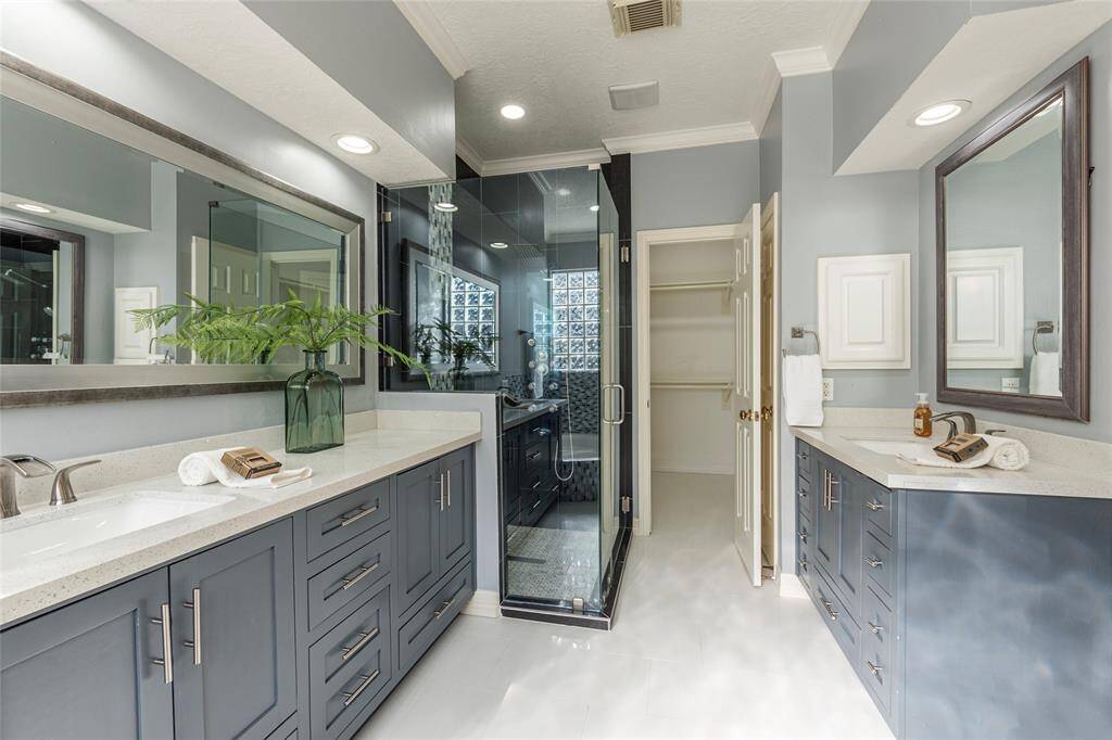 Another view of the dual vanities with one of two walk in closets in the background.