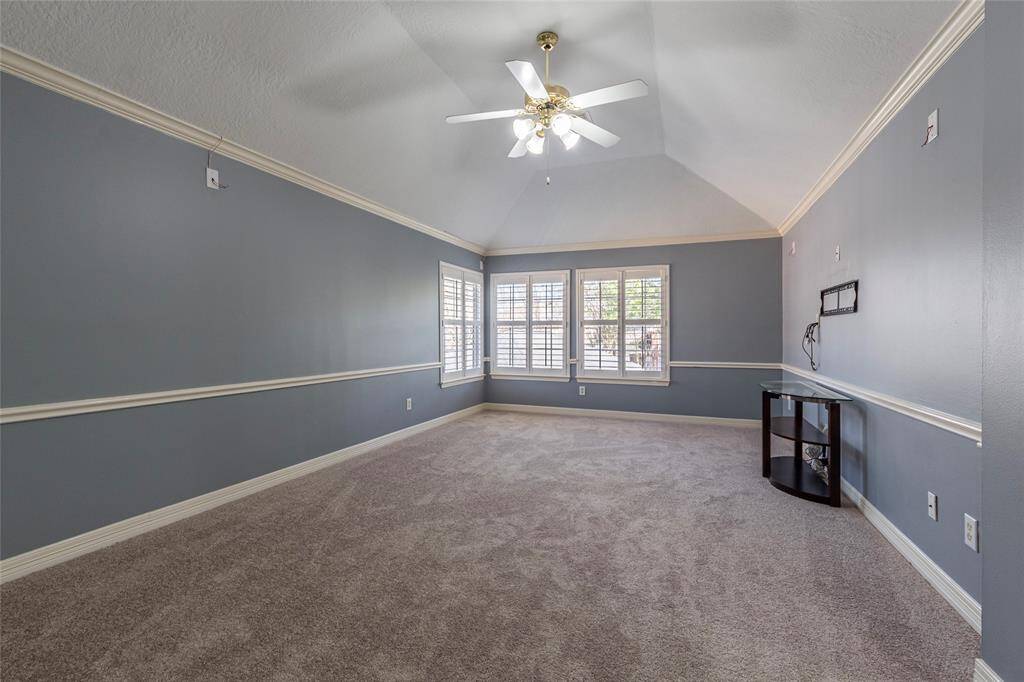 NEW CARPET INSTALLED JANUARY 2025. Spacious game room with high ceilings, surround sound wiring, crown molding and Plantation shutters.