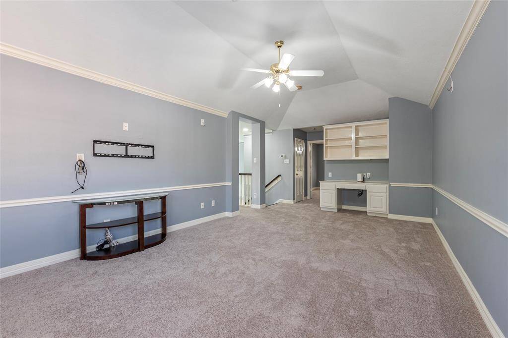 Another view of the large game room with NEW carpet, built in homework station/desk and storage shelves.