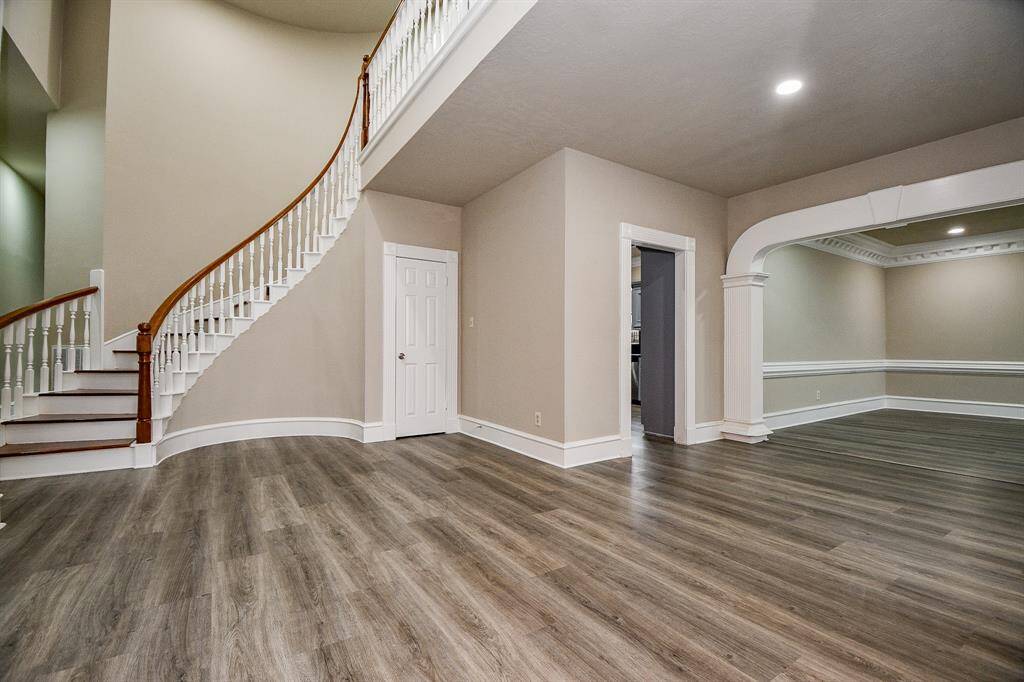 To the right of the entrance, a formal dining room awaits, featuring exquisite crown molding and creating an elegant space for entertaining.