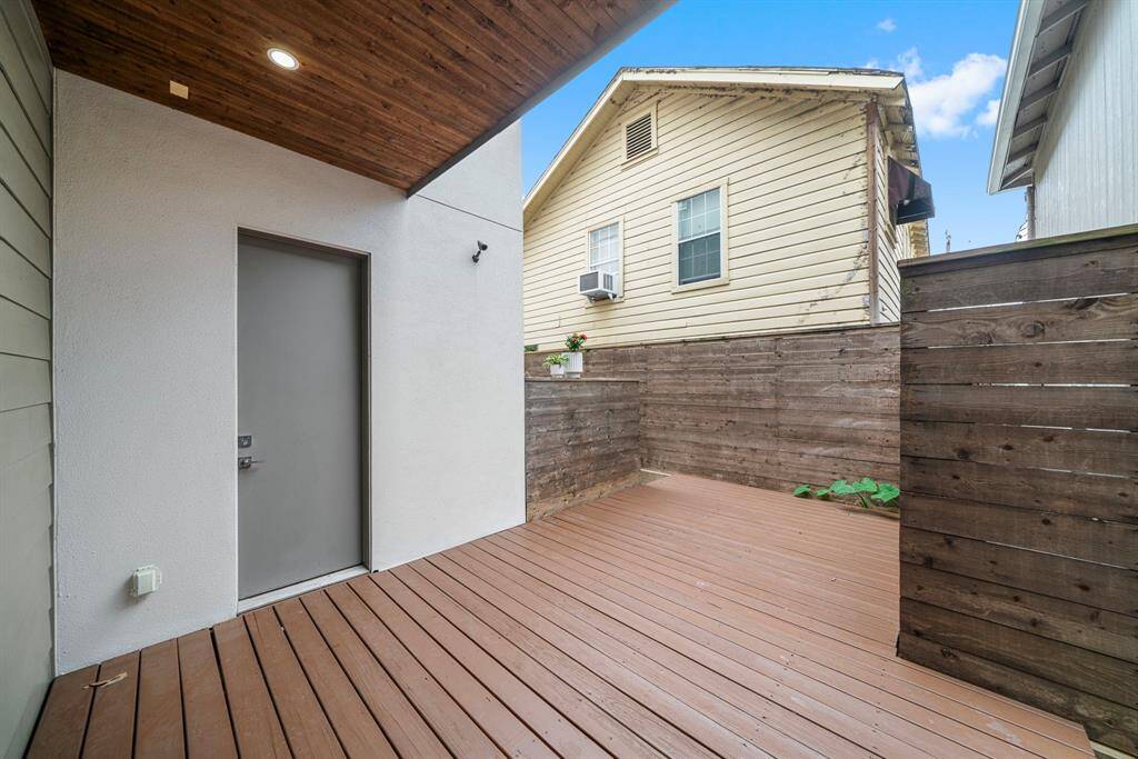 Alternate view of the 1st floor deck/outdoor area.  Doorway offers a direct entry to the garage for access to deck furniture/etc.  Additional hardscaped space around the corner for low maintenance, but could easily be converted to a grassy area.