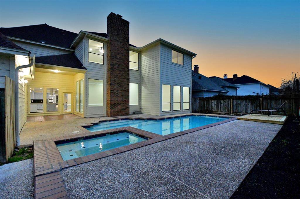 This stunning residence commands attention even at twilight. The long, curved driveway winds its way through a lush, green lawn, leading to a gated entrance that hints at the privacy and exclusivity within. The home's grand scale and impressive architecture are showcased beautifully against the backdrop of the evening sky.