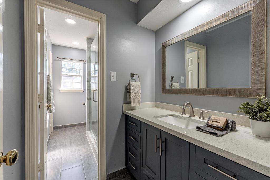 3rd full bathroom upstairs is also updated with Quartz countertop, framed mirror, updated seamless glass shower and private door separating the vanity from the shower area.