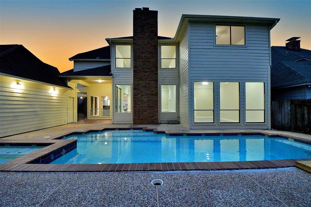 This aerial view showcases the impressive scale and layout of this property.  A sparkling pool and hot tub take center stage in the backyard, creating a private oasis for relaxation and entertainment.